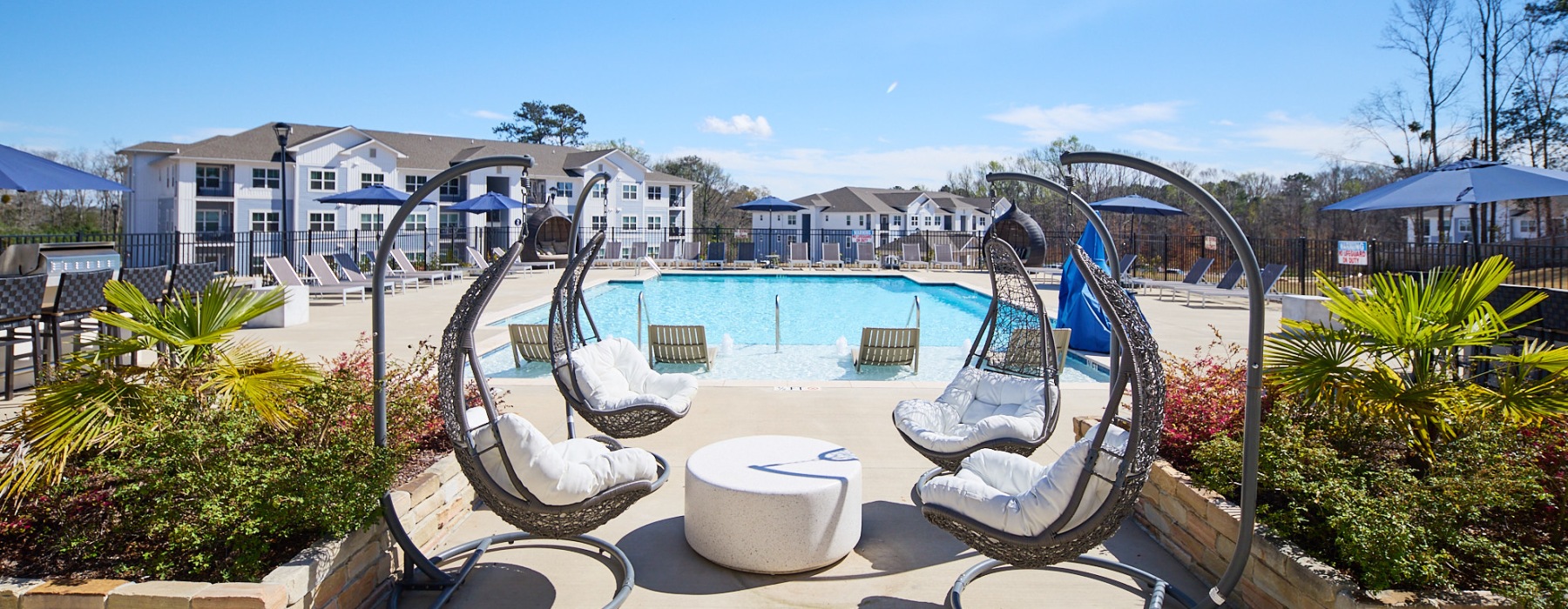 a courtyard with a pool and chairs